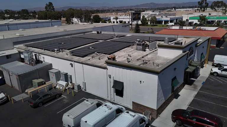 Aerial drone view of Francisco’s Meat Company commercial building with a flat-roof solar array