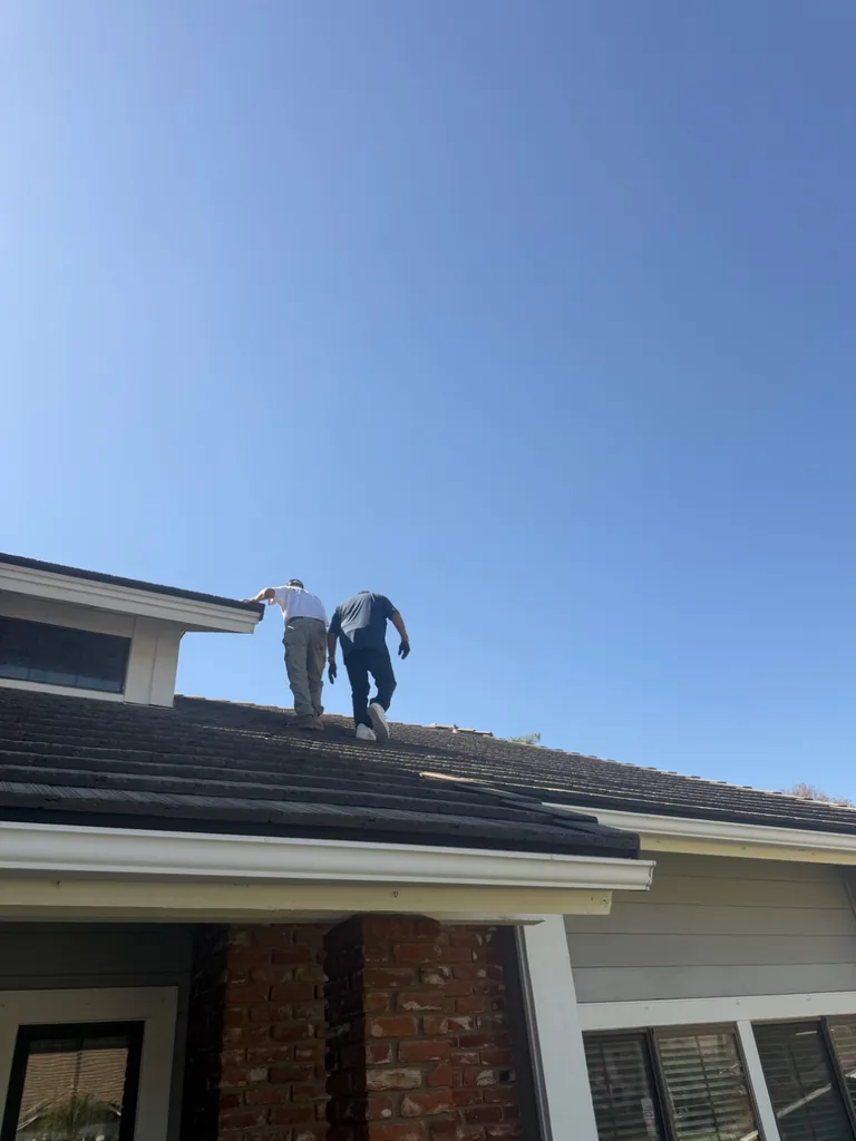 Installation crew working on a residential tile roof at elevation