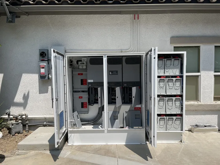 Wide view of a residential solar battery backup cabinet installation